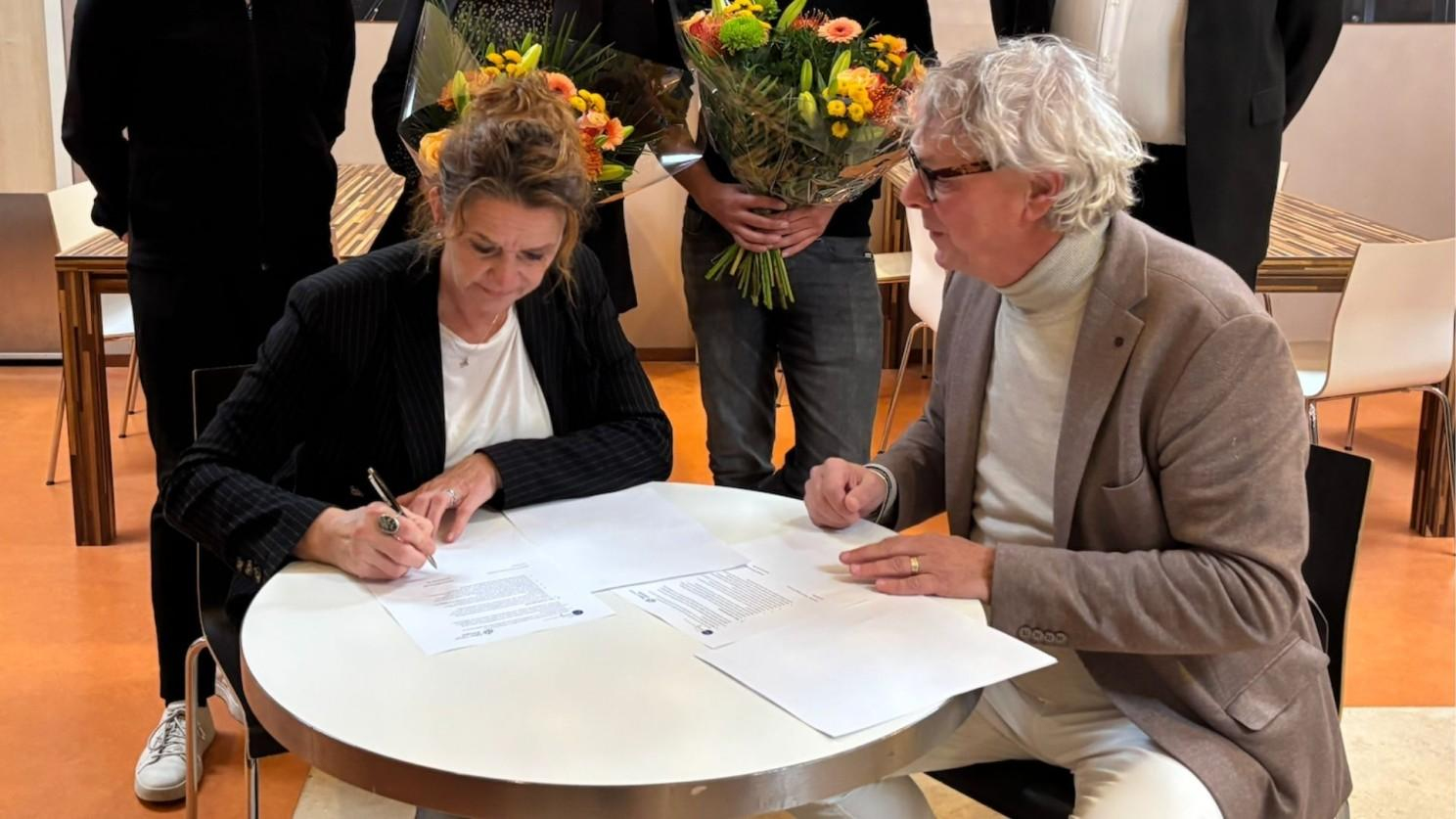 Jessica van der Bilt en Stef Macke ondertekenen de samenwerkingsovereenkomst. 